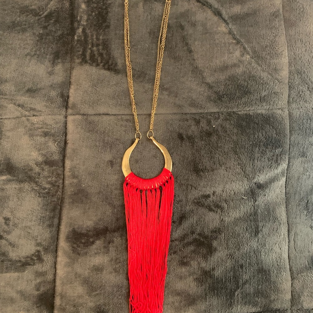 Long necklace with gold chain attached. New with tags. Red fabrics on circle.